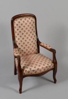 une chaise ancienne dont le dossier et les accoudoirs sont recouverts d'un tissu à motifs floraux