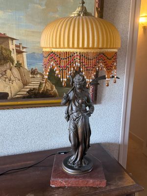 une lampe posée sur une table devant un tableau