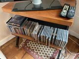 a television on a stand with a lot of dvd ' s