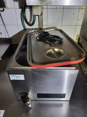 stainless steel counter top with a hot plate on top of it in a kitchen