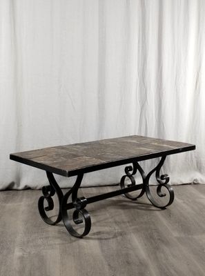 La table est en fer et possède un plateau en marbre.