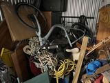 a pile of junk in a garage with a bike in it