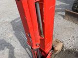 a red machine that is sitting in the dirt