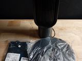 un ventilateur noir posé sur une table en bois