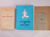 trois livres posés sur une table recouverte d'une nappe blanche