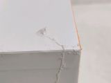 a close up of a piece of white paint on a piece of wood