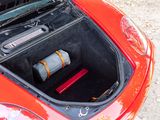 a trunk of a red car with a bottle of wine in it
