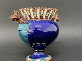 a blue vase with a bird on top of it