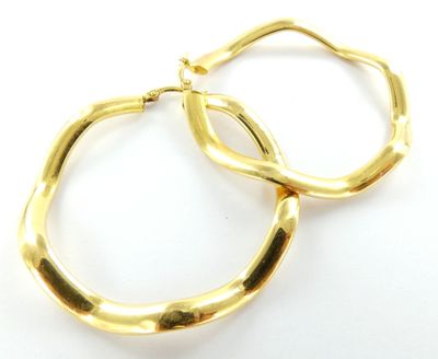 deux paires de boucles d'oreilles en or sur fond blanc