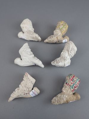 six figurines en céramique de formes et de tailles différentes posées sur une surface grise