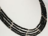 a close up of a black beaded necklace on a mannequin