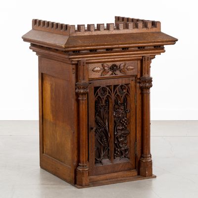 une vieille table en bois dont le plateau est orné de sculptures