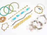 de nombreux bracelets de toutes sortes, disposés sur une surface blanche
