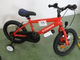 un vélo rouge portant un numéro, dans une pièce