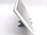 a tablet computer sitting on a stand on a white surface