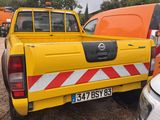 a yellow truck that is parked next to a white van