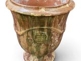 a large brown vase with a green design on it