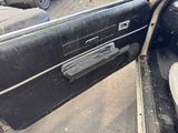a black car with a door open on the side of the road