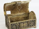 a small gold box with a ring on top of it