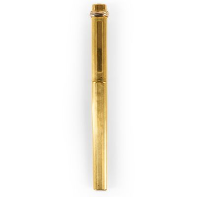 a close up of a gold pen on a white background