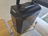 a black paper shredder sitting on top of a wooden desk