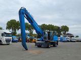 a blue crane on the back of a truck in a parking lot