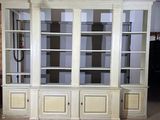 une bibliothèque blanche aux portes vitrées, placée au milieu d'une pièce