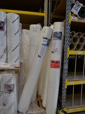 many rolls of white material on the shelves in the store