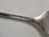 a silver spoon with a metal handle sitting on a table