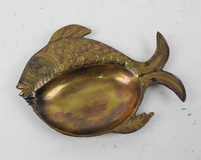 a gold fish shaped dish with a spoon in it
