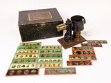 une boîte de cartes illustrées posée à côté d'une vieille machine à coudre