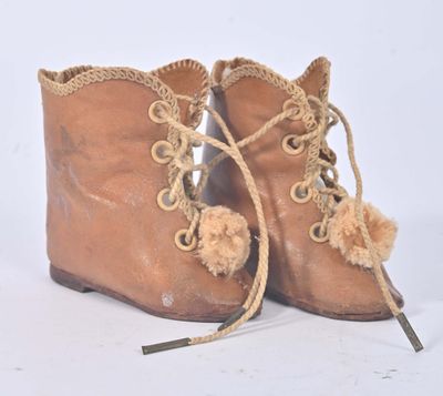 une paire de bottes en cuir marron ornées de pompons