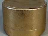 a gold box with a lid sitting on a table