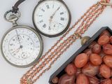 une boîte de perles et une montre de poche posées sur une table