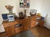 a wooden cabinet with a microwave on top of it next to a bed