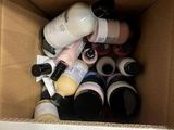 a cardboard box filled with assorted bottles of paint