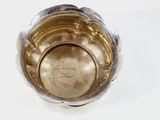 a silver bowl with a gold object inside of it