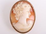 un gros plan sur le visage d'une femme dans une broche en or