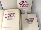 trois livres sont posés sur une table recouverte d'une nappe blanche