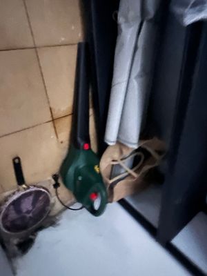 a green blower sitting in the corner of a bathroom
