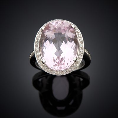 an oval pink sapphire and diamond ring on a black surface