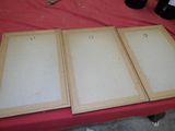 trois cadres en bois vides sur une table avec une nappe rouge