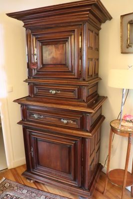 a tall wooden cabinet in the corner of a room