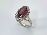 a close up of a ring with a red stone on it