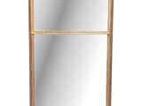 a gold framed mirror on a white wall with a white background