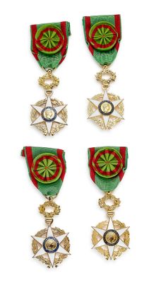 quatre médailles et une croix sont exposées sur un fond blanc
