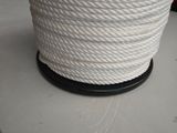 un gros plan sur une bobine de corde blanche posée sur une table