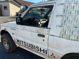 un camion blanc sur le flanc duquel est accroché un journal