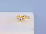 une bague en or sertie de deux diamants, posée sur un bloc de marbre