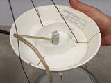 a person holding a white plate with a wire attached to it
